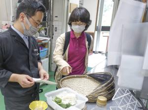 とってきた野草について、鹿野川荘の料理人の方に説明している様子です。