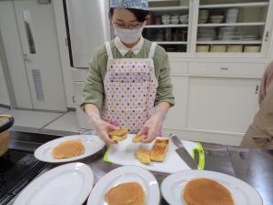 焼きあがったパンケーキを食べやすい大きさに切り分けています。