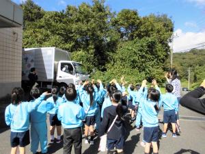 出発する給食車を見送る子供たち