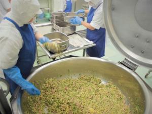 冷やし中華の具を食缶にいれる様子