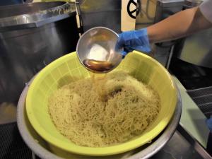 麺にごま油をまぶす様子