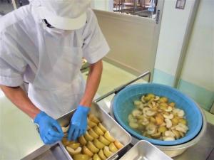 調理員が梨を食缶に入れる様子
