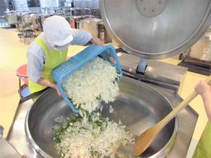 釜にピーマンと玉ねぎを入れるところ