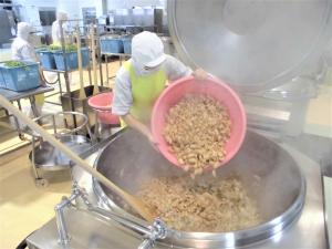 揚げた鶏肉を釜に入れるところ