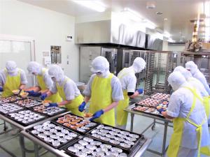 調理員さん達がアルミカップに具を入れるところ