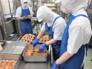 グラタンを各クラスに配缶している様子