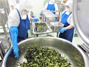 出来上がったわかめサラダをクラス毎の食缶に入れる様子