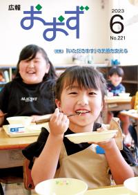 表紙（給食をおいしそうに食べる小学生）